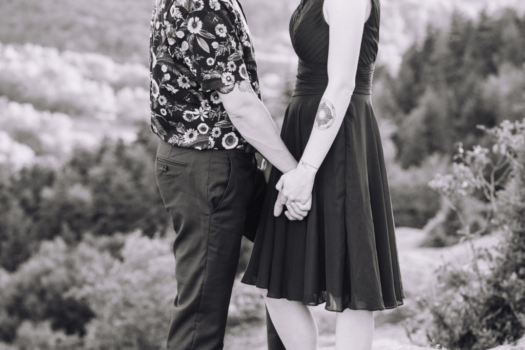 Black and White Image of Man and Woman holding hands in the white mountains