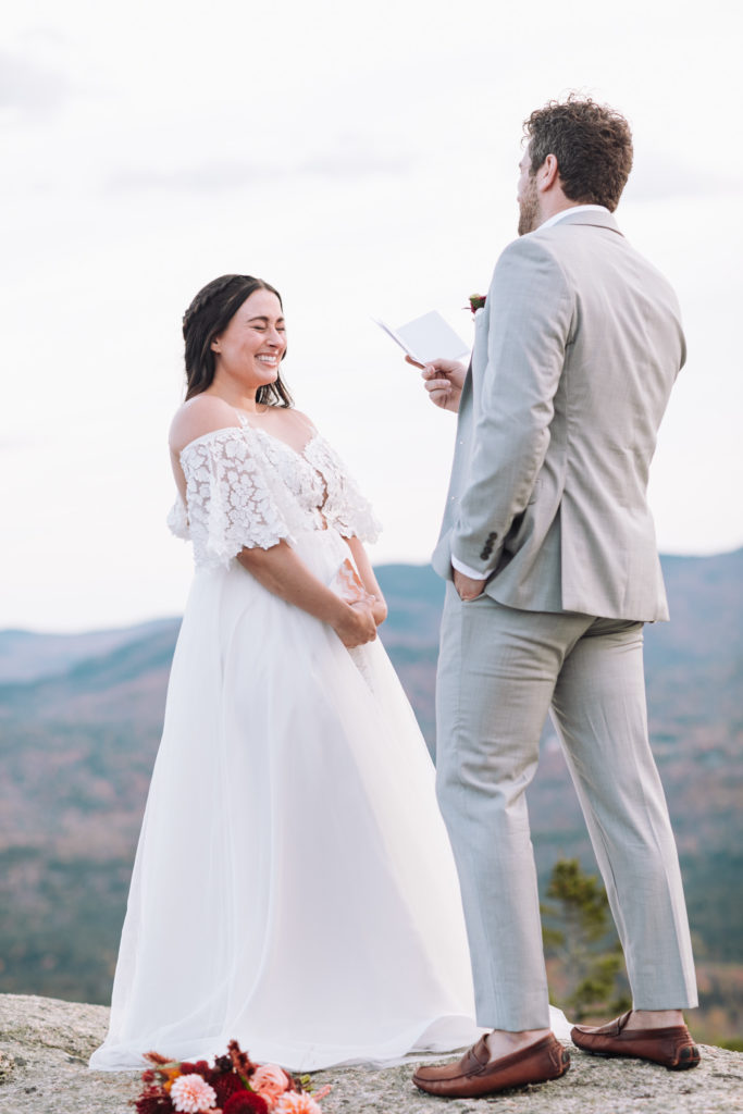 Bride laughs at husbands vows on their elopement day in New England in the White Mountains