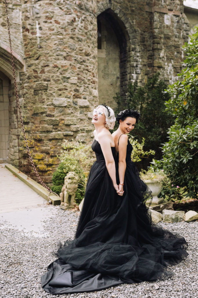 Two Brides stand back to back waiting for their first look on their Elopement day at Hammond Castle
