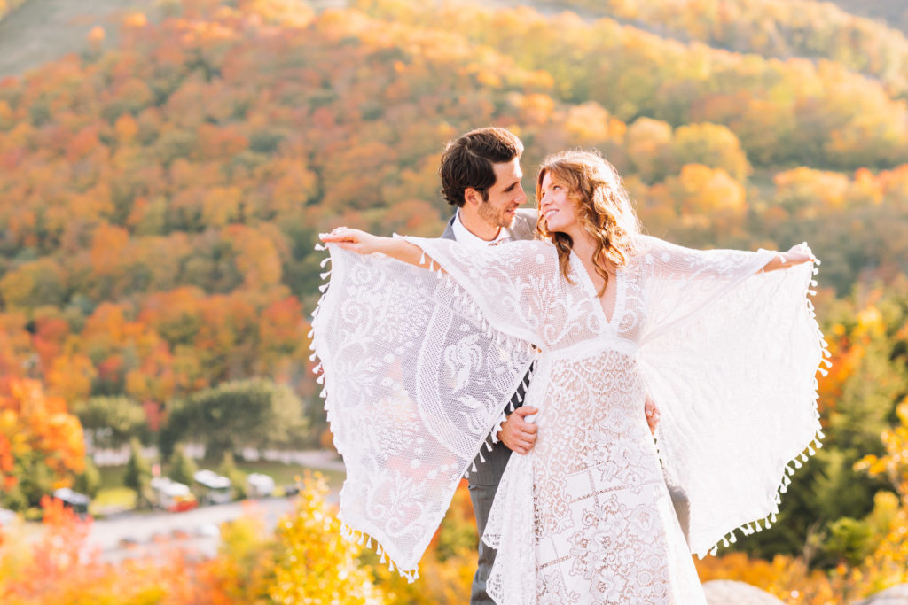 Bride shows off her wings to husband in teh white mountains