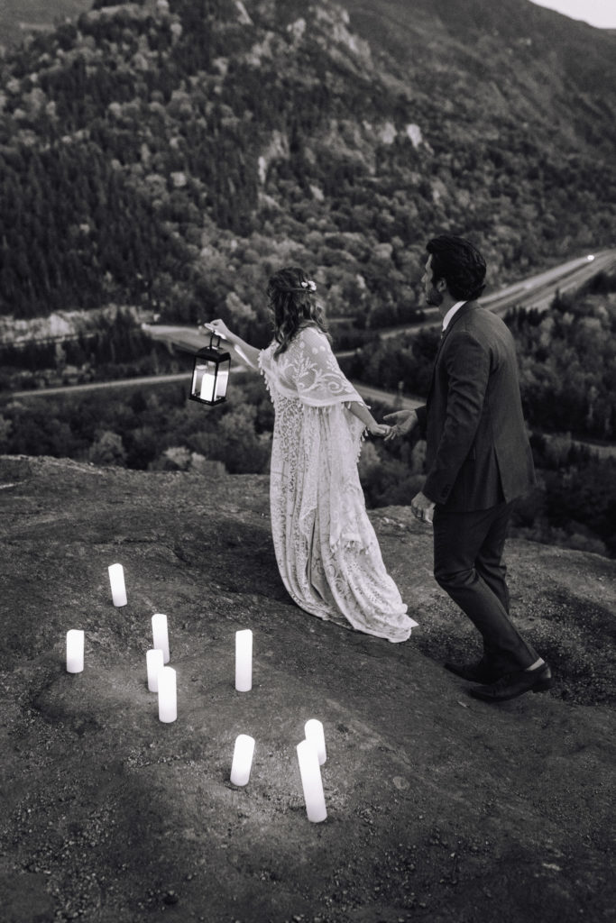 Woman in wedding dress leads man through the mountains 