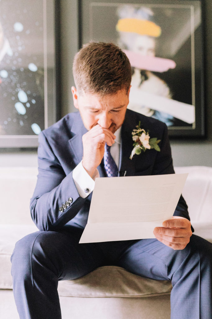 groom reading a touching note from his bride on their wedding day