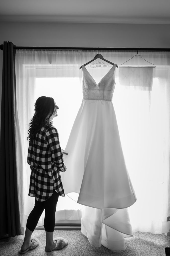 bride checking out her wedding dress as she gets ready on her wedding day 